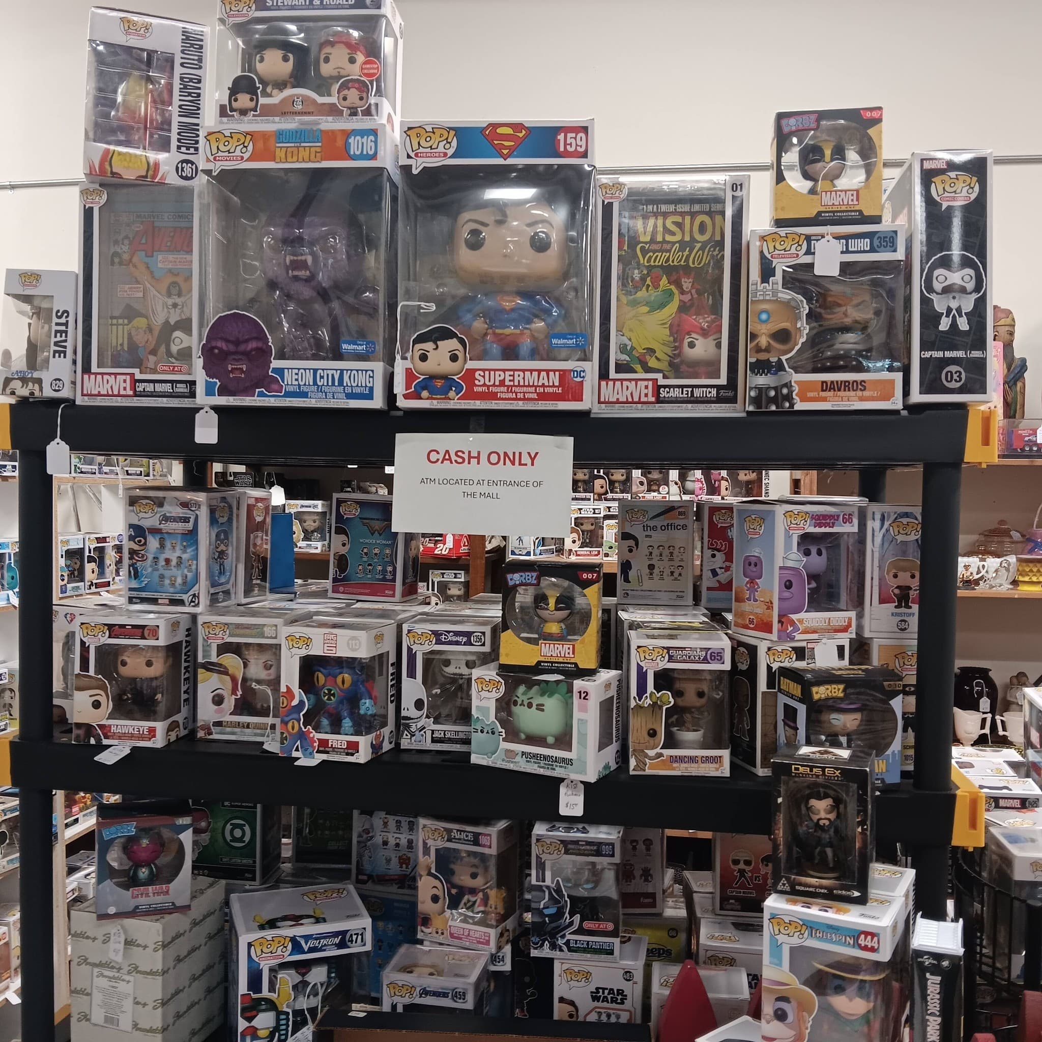Shelves packed with Funko Pop figures including Superman, Wonder Woman, and other pop culture characters