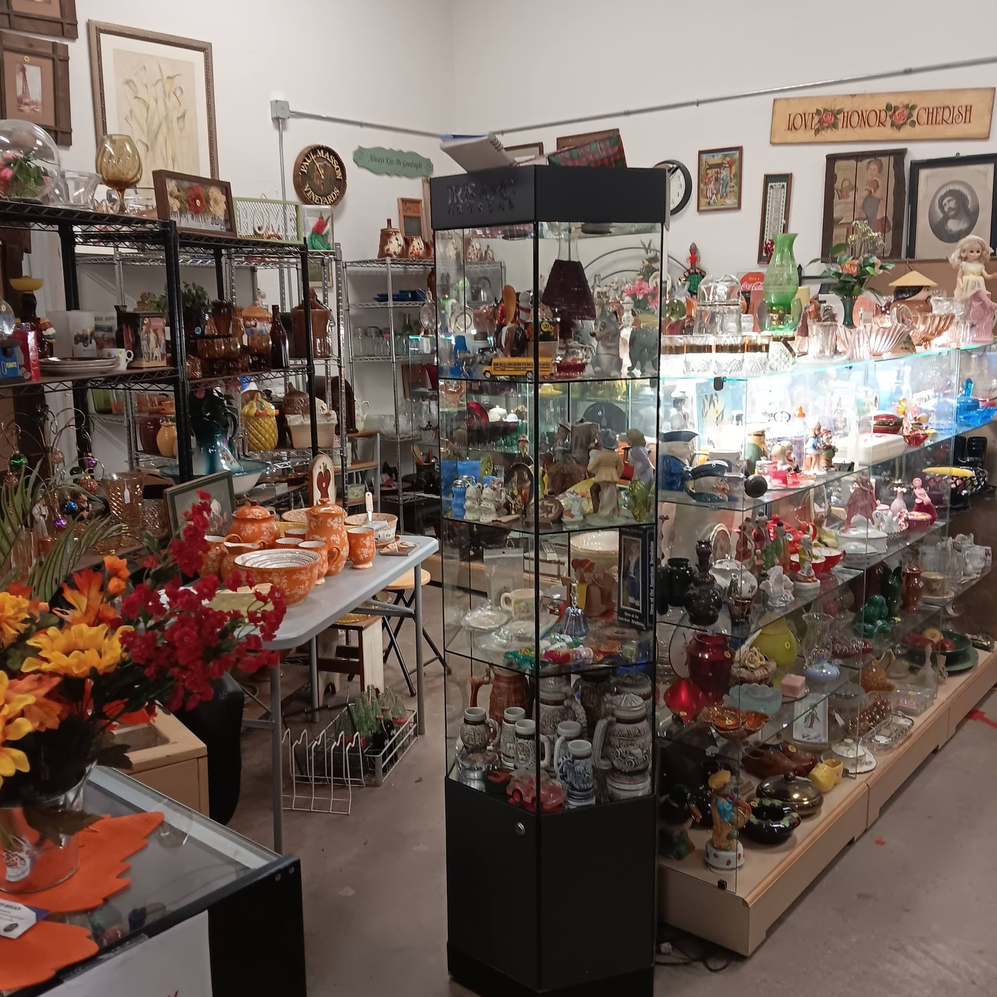 Glass display cases filled with colorful antique glassware, figurines, and vintage collectibles